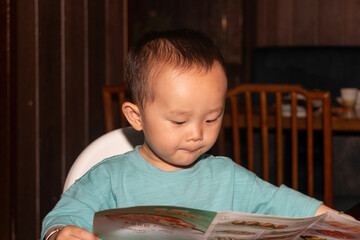 little boy reading a menu