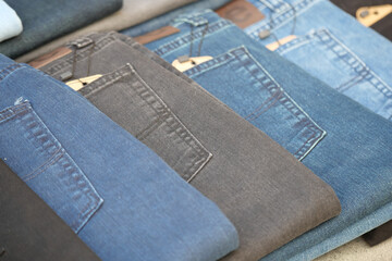 Collection of denim jeans in various shades at a market