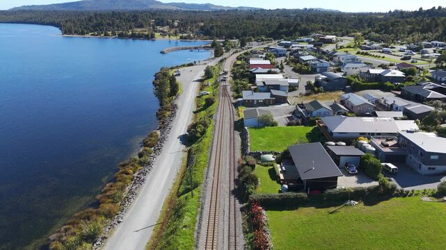Drone flies above railway by Lake Brunner and Moana town, New Zealand
