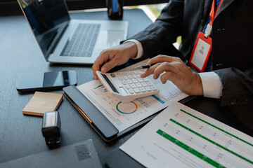 a businessman reviews the company's financial documents in his office, the accountant is rushing to check the figures in the documents before submitting them to the tax office