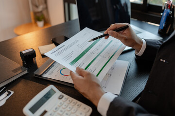 a businessman reviews the company's financial documents in his office, the accountant is rushing to check the figures in the documents before submitting them to the tax office