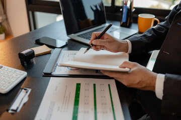 a businessman reviews the company's financial documents in his office, the accountant is rushing to check the figures in the documents before submitting them to the tax office