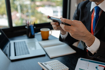 a businessman woks with a foreign company and uses a smartphone to help send and receive information, marketing manager sends statistic information to accounting department via a smartphone