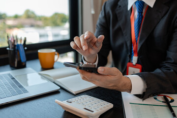 a businessman woks with a foreign company and uses a smartphone to help send and receive information, marketing manager sends statistic information to accounting department via a smartphone