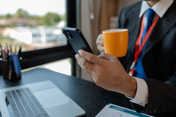 a businessman woks with a foreign company and uses a smartphone to help send and receive information, marketing manager sends statistic information to accounting department via a smartphone