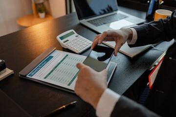 a businessman woks with a foreign company and uses a smartphone to help send and receive information, marketing manager sends statistic information to accounting department via a smartphone