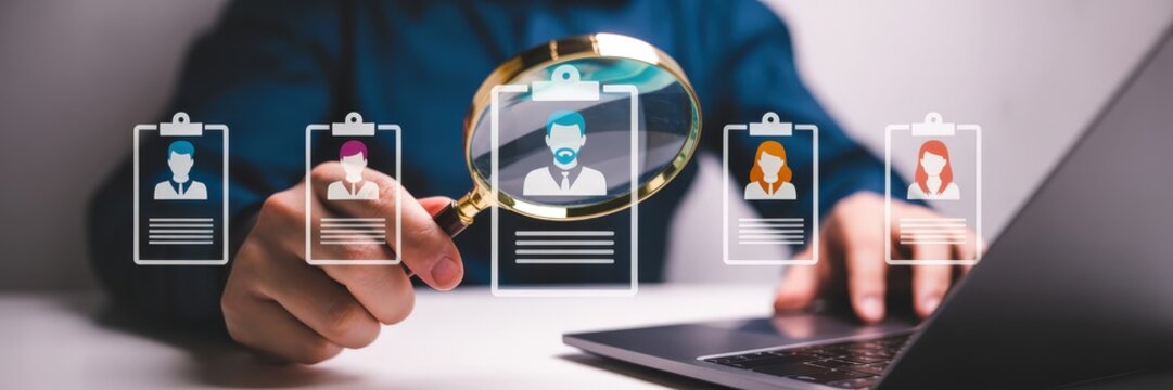 Person's hands examining digital resumes on a laptop. - Powered by Adobe