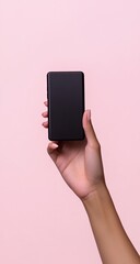 Hand holding a black smartphone against a light pink background