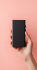 Hand holding a black rectangular portable battery