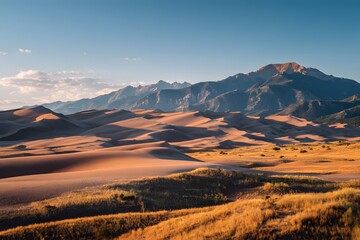 Panoramic photograph of the Great Sand Dunes in Colorado, with a mountain range in the background