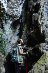 A determined hiker stands confidently with a trekking pole inside a rocky canyon, surrounded by rugged cliffs. The scene symbolizes adventure, strength, and the spirit of exploration in nature.