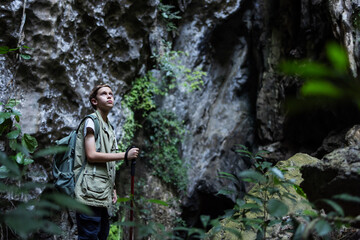 A determined hiker stands confidently with a trekking pole inside a rocky canyon, surrounded by rugged cliffs. The scene symbolizes adventure, strength, and the spirit of exploration in nature.