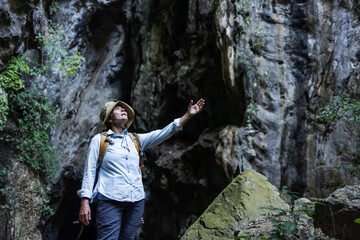 A joyful hiker stands with arms raised inside a rocky canyon, surrounded by lush vegetation. The scene captures freedom, triumph, and a deep connection with nature during an adventurous journey.