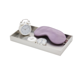 Sleek silver nightstand organizer tray featuring an alarm clock, sleep mask, and wireless charging pad for a tidy bedtime routine