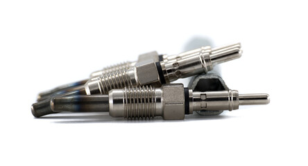 Group of new glow plugs for a diesel engine, isolated on a white background.