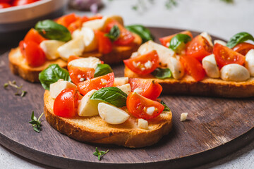 Bruschetta caprese with cherry tomatoes and mozzarella garnished with basil