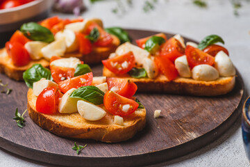 Bruschetta caprese with cherry tomatoes and mozzarella garnished with basil