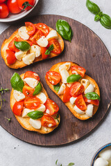 Bruschetta caprese with cherry tomatoes and mozzarella garnished with basil