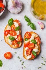 Bruschetta caprese with cherry tomatoes and mozzarella garnished with basil
