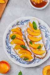 Bruschetta with ricotta cheese, sliced nectarines, basil and honey on a plate
