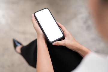 Top view Woman sitting and holding blank screen mock up mobile phone