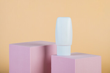 Plastic white tube for cream or lotion. Skin care or sunscreen cosmetic with stylish props on cream...