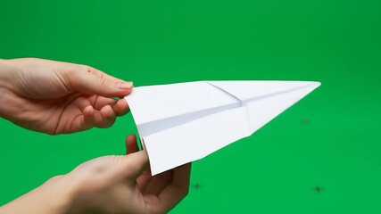 Hands folding paper airplane