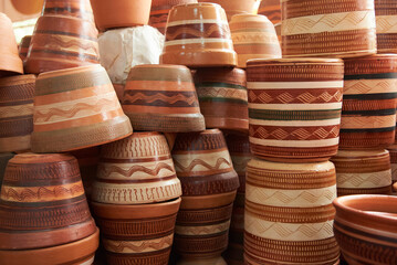 Ceramic pottery pots with different designs stacked for sale in Raquira, Boyaca, Colombia, a tourist town known for its handmade ceramic products.