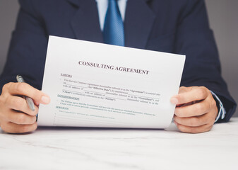 Businessman holding consulting agreement document, concept of professional service contract.