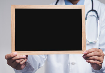 Doctor in white coat holding empty chalkboard sign, concept for custom message or health advice.