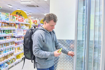 Man Carefully Selects Beverage From Cooler Display