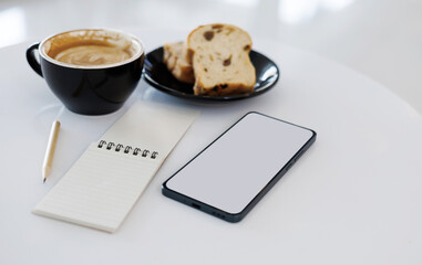 latte coffee with toast for breakfast and working with mobile phone, notebook on white table