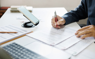 asian businessman working on desk reading and checking financial documents and business contract...