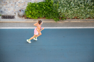 Dedicated female runner training hard staying fit achieving goals urban street exercise healthy...