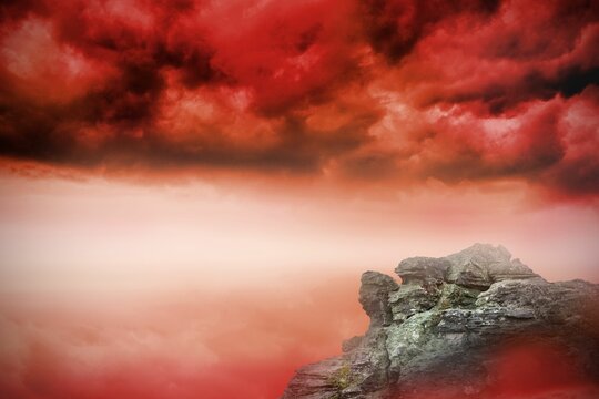 Fototapeta Large rock overlooking red sky