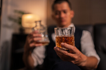 Bartender is pouring whiskey into a glass a customer's glass.	