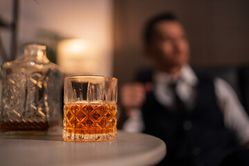 Bartender is pouring whiskey into a glass a customer's glass.	