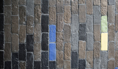 Detail of a brick wall with blue and yellow sign. Background