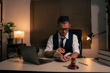 Lawyers are sitting in a meeting, searching for legal documents at the office.	