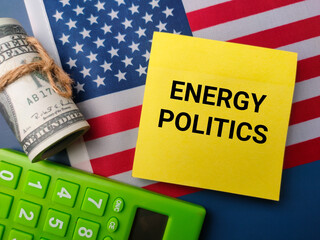 Fototapeta premium Top view banknotes and calculator with the word ENERGY POLITICS on a us flag background