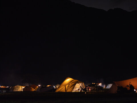 Night camping tents glowing in the dark field