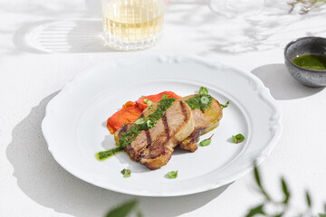 Grilled beef tongue with roasted vegetables, bright lighting, minimal overhead presentation