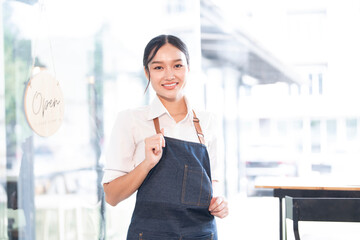 Portrait of smiling waitress standing at her shop