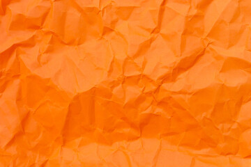 Top view and full frame of wrinkled or crumpled orange paper used as crumpled orange paper background texture.