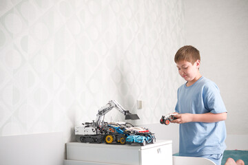 A young child joyfully playing with colorful toy trucks in a modern, stylish bedroom space