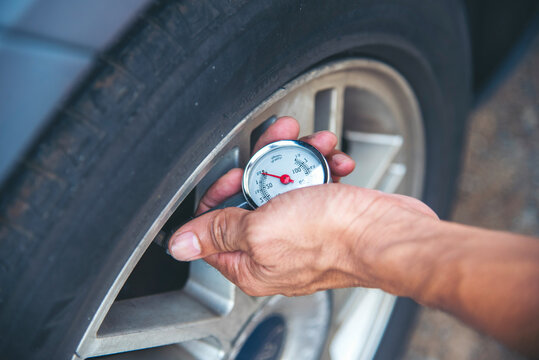 Mechanic man hands checking car tires outdoor on site service auto garage for automotive mobile center services. Technician workshop repair checking tyres car motor vehicles service mechanical hands