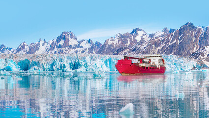 Arctic ship leaving Tasiilaq after having unloaded at the docks in the harbour - Tasiilaq, Greenland