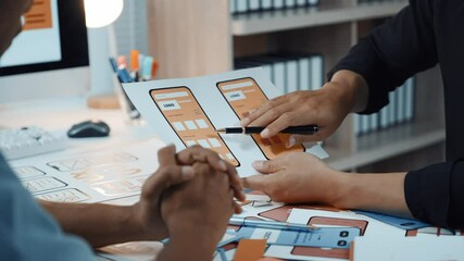 UX and UI designers collaborating on mobile app design, brainstorming wireframes and prototyping innovative digital product at modern startup workspace - Powered by Adobe