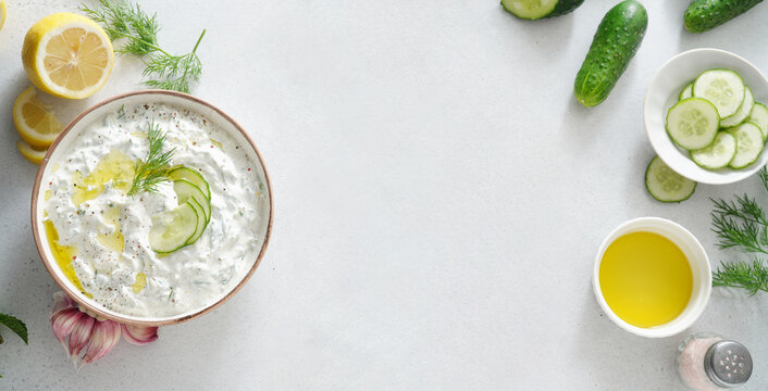 Tzatziki salad with roasted bread in white bowl on white background. Homemade Tzatziki salad with olive oil and copy space. Top view.