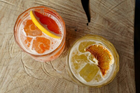 Top view of two fruity cocktails on a wooden table